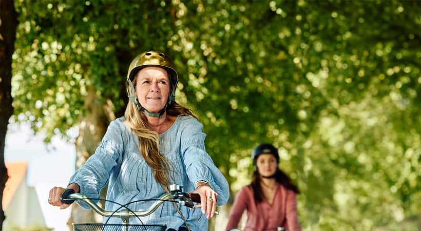 To kvinner sitter ved et bord og snakker mens de spiser