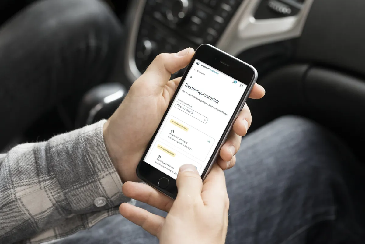 Mann bestiller fra nettbutikken med mobil i bil