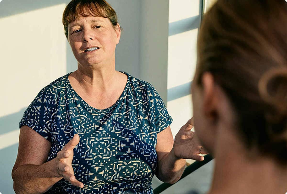 Kvinne snakker med en annen med gestikulerende hender
