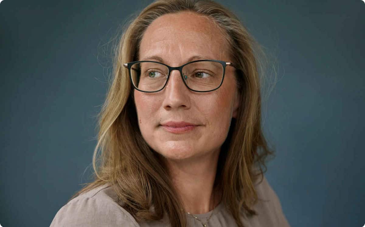 Portrettbilde av Carina som ser til siden med et lett smil