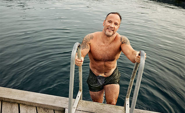 Joshua på vei opp av vannet, med hendene på badestigen